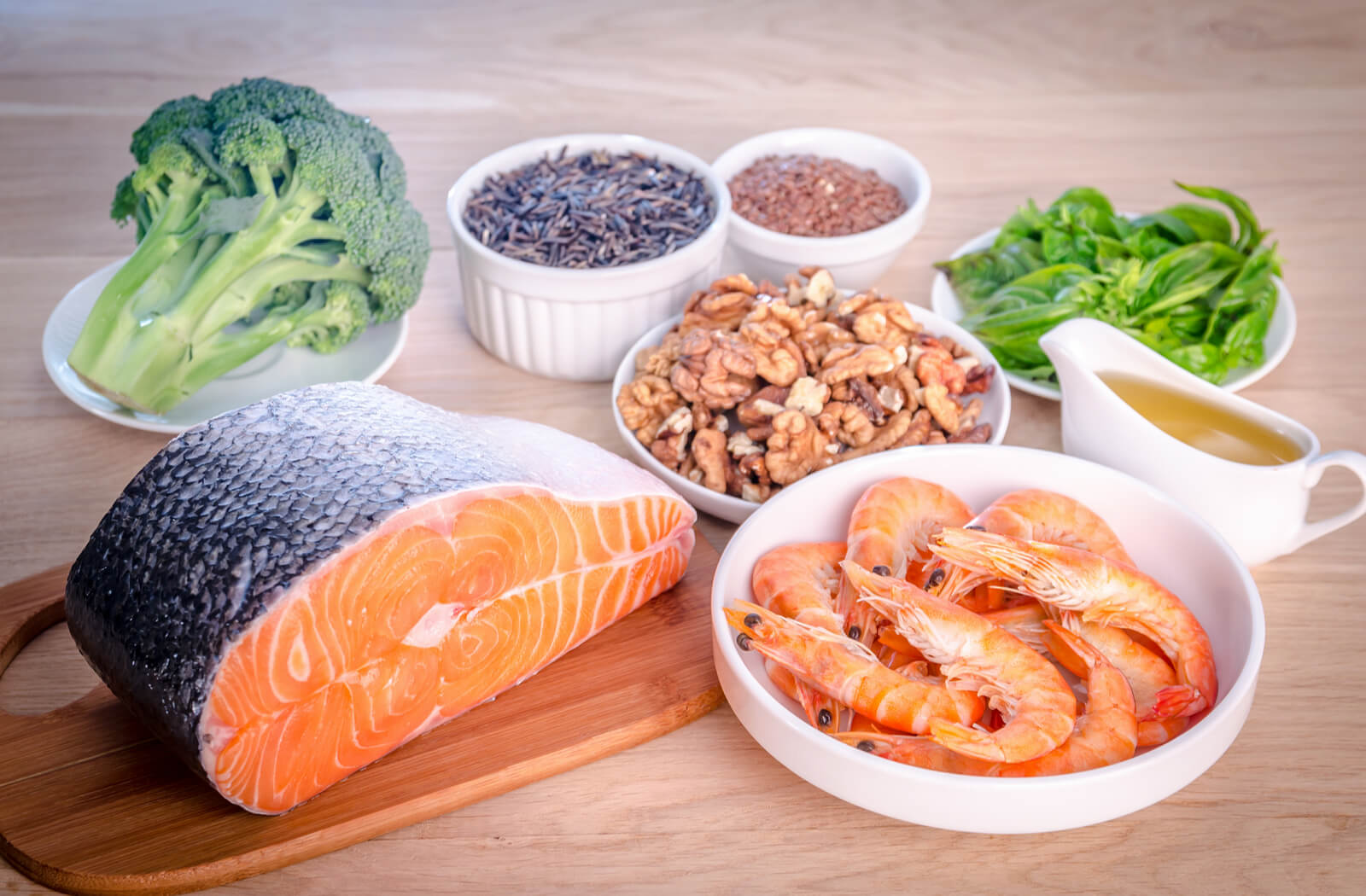 an assortment of food good for eyes. broccoli salmon prawns avocado walnuts